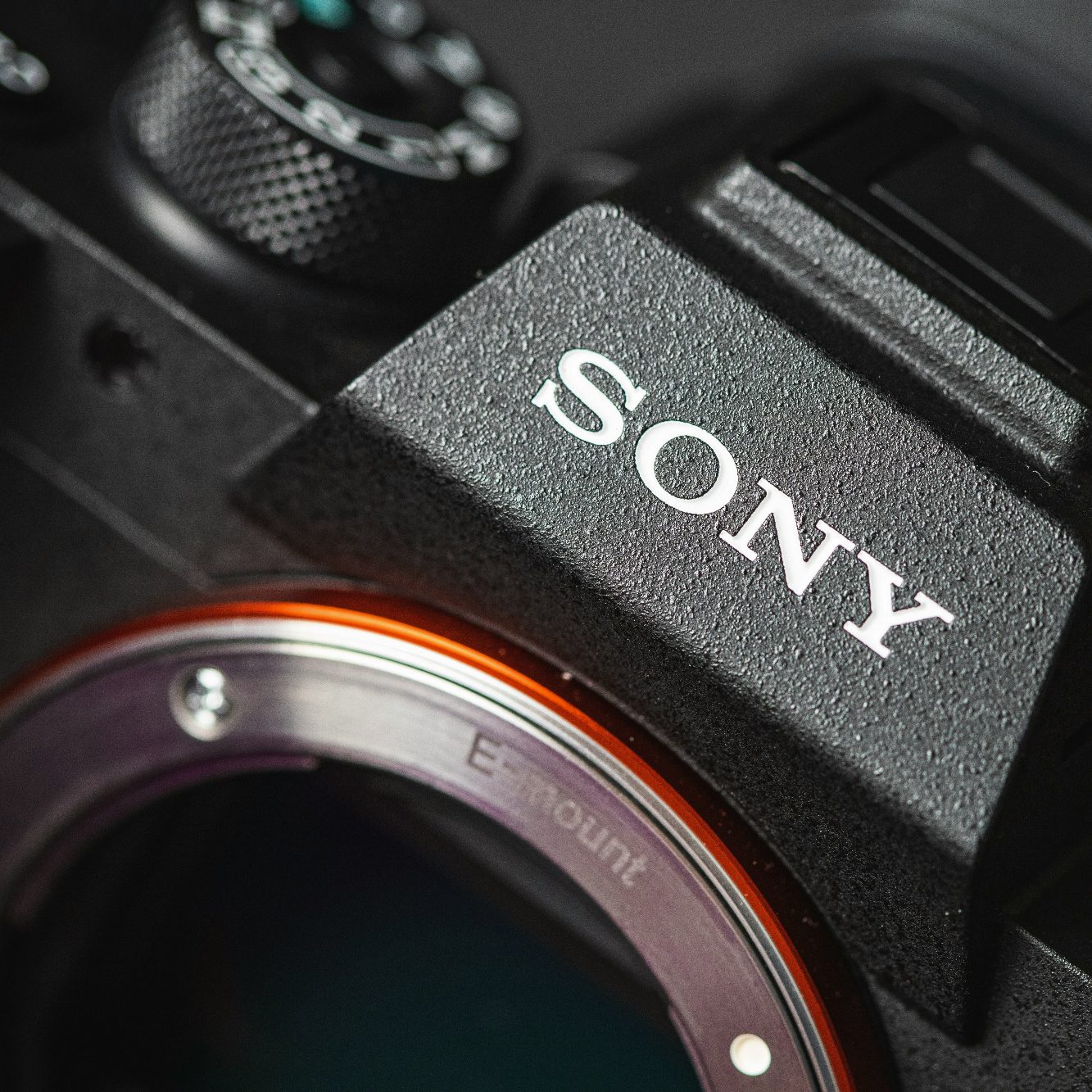 Nahaufnahme eines Sony-Kameragehäuses mit einem leuchtend orangefarbenen Ring.